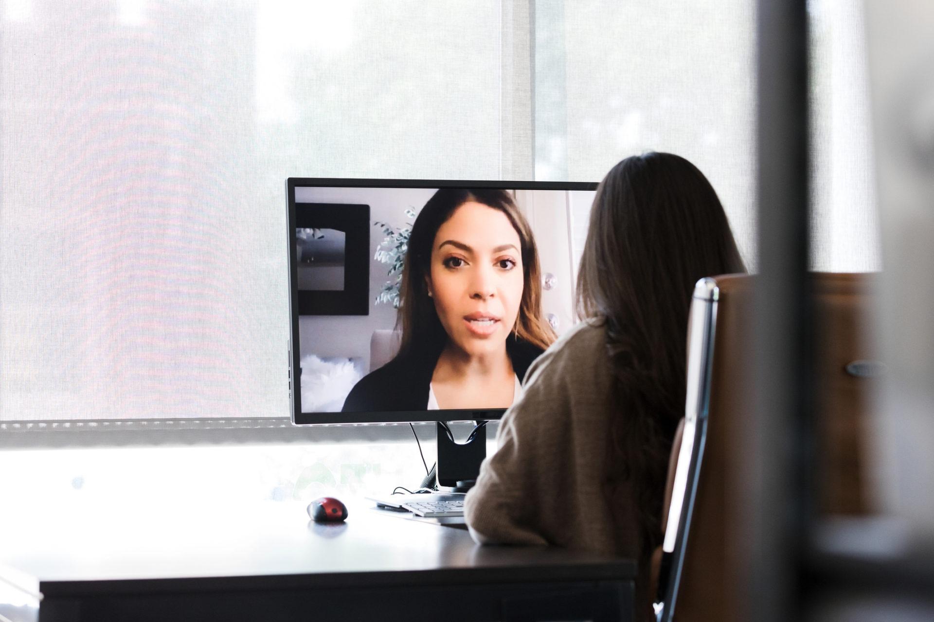 Alone in her office, an unrecognizable woman video conferences with her boss.