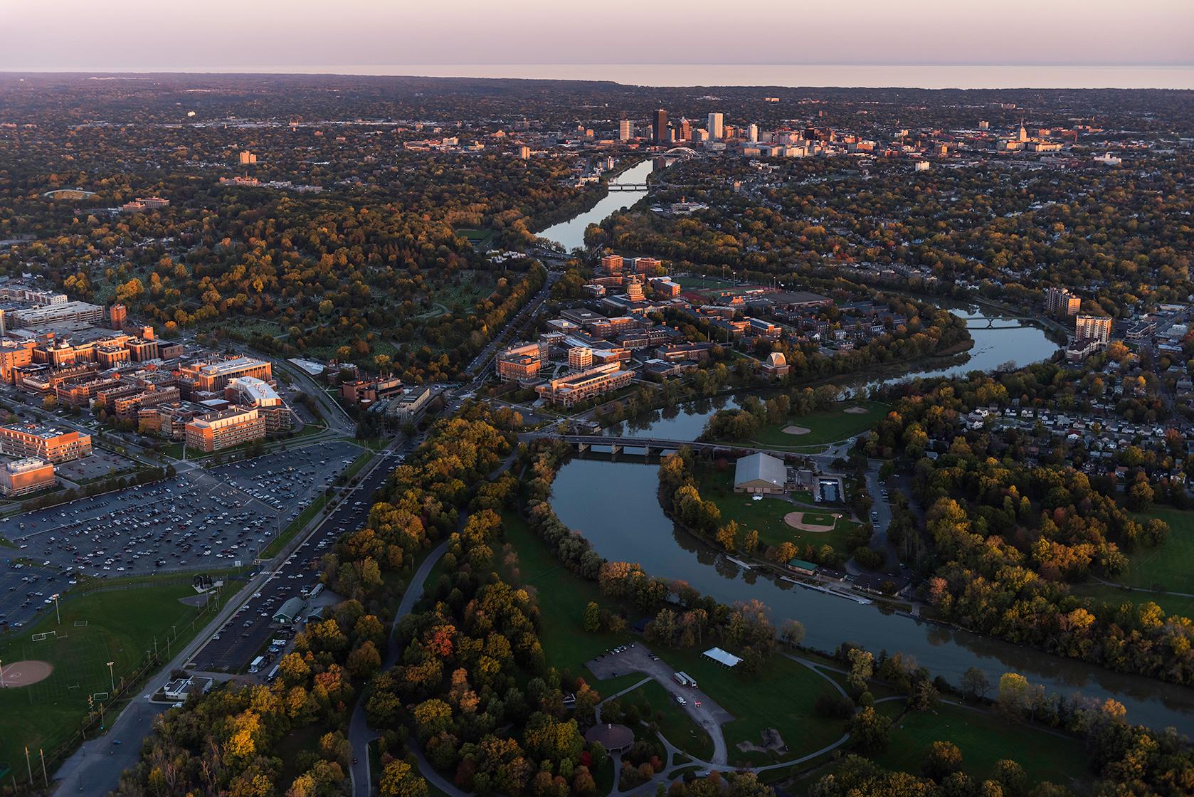 Aerial photo of University of Rochester's River Campus and Medical Center along with downtown Rochester, NY in in the evening.